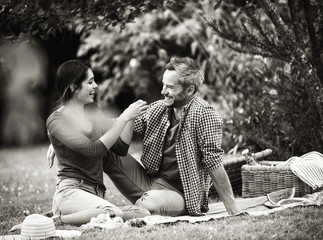 Wall Mural - Young couple sitting on grass during a picnic