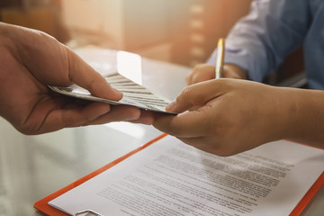 Man offering batch of hundred dollar bills. Close up of business man signing contract making a deal, business contract details.