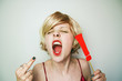 © nanihta - Mujer joven y rubia gritando, haciendo un gesto obsceno con la mano y sujetado un signo de exclamación