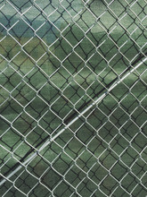Detail Of Chain Link Fence And Green Fabric At Construction Site