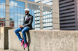 © Kristen Curette Photography LLC/Stocksy - A handsome young male wearing stylish attire sitting outdoors in the city