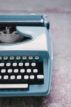 Blue Retro Typewriter Against A Concrete Background