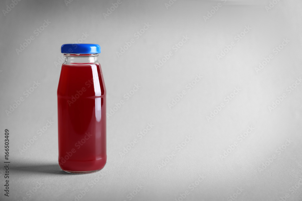 Delicious juice in bottle on light background