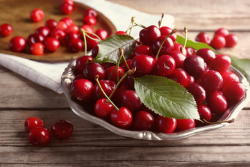 Canvas Print - Plate with sweet cherries on wooden background