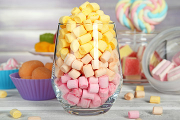 Sticker - Composition with marshmallows and different candies on wooden table