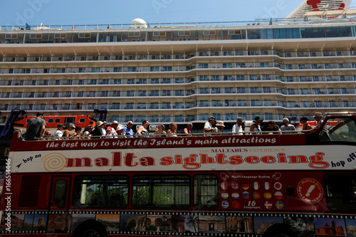 An Open Top Sightseeing Double Decker Bus Arrives Near The