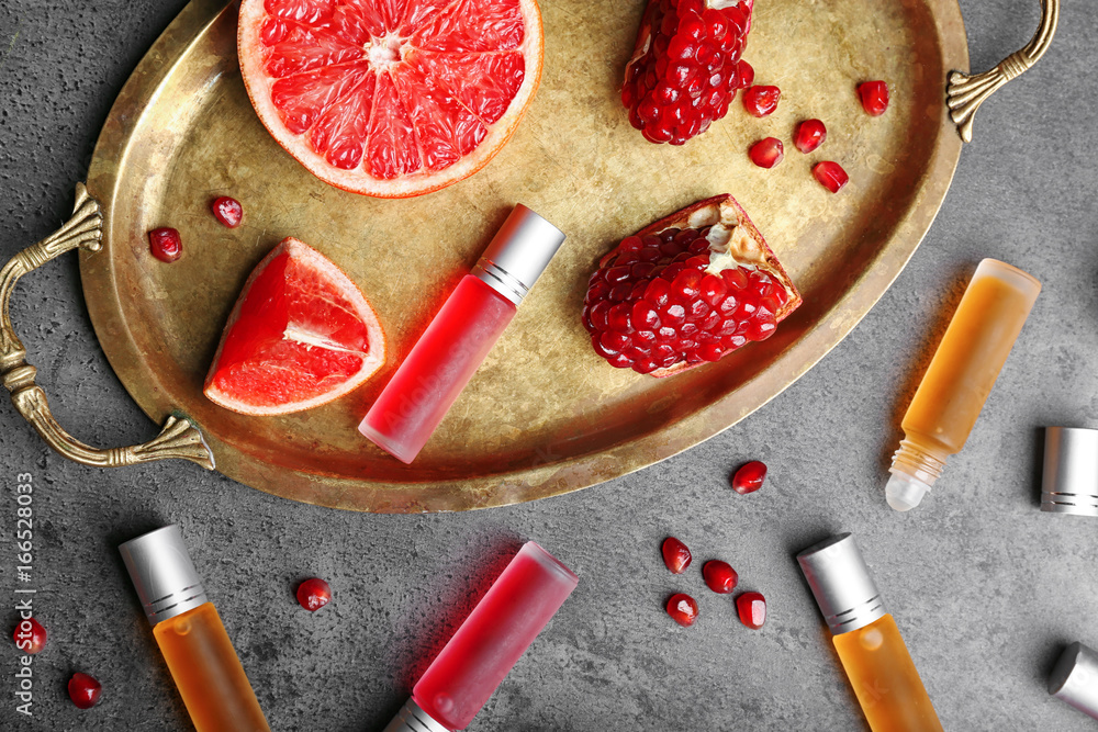 Composition with different bottles of perfume and fruits on table