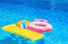 Inflatable Rings, Mattress And Ball In Blue Swimming Pool