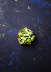 Wall Mural - Green hazelnuts in a bowl, dark background, top view