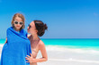 © travnikovstudio - Happy mother and little girl on the beach vacation. Little girl in towel on the seashore