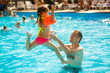 © Angelov - Happy active family young father and his cute daughter adorable toddler girl playing in a swimming pool jumping into the water enjoying summer vacation