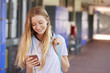 © Monkey Business - Happy teenage girl using smartphone in school corridor