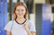 © Monkey Business - Happy white teenage girl smiling in high school corridor
