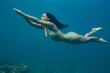 © willyam - A brunette girl diving into blue sea water. Underwater photography of sport activity