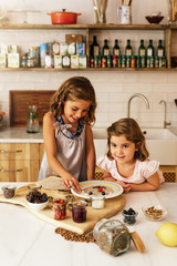 Wall Mural - Little sisters girl preparing baking cookies.