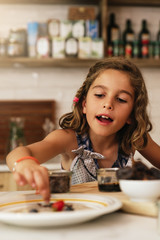 Wall Mural - Portrait of little girl preparing baking cookies.