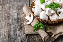 Fresh Champignon Mushrooms In A Basket On Wooden Table, Overhead