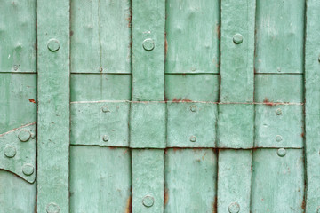 Wall Mural - Old green painted riveted metal door detail