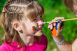 © Svetlana - Little happy sisters play with colors in the park, children play, children paint each other