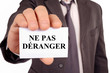 © Richard Villalon - Homme tenant une carte sur laquelle est écrit ne pas déranger