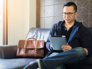 Handsome young man wearing glasses and working with tablet