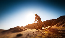 Man Rides Bicycle In The Dry Desert Terrain