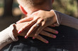 Women hands with engagement ring over men neck