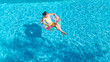 © Iuliia Sokolovska - Aerial view of girl in swimming pool from above, kid swim on inflatable ring donut and has fun in water on family vacation