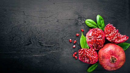 Fresh pomegranate on a dark Wooden surface. Top view.