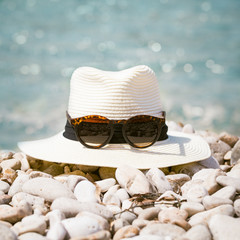 Summer compositions with woman's hat and sunglasses on the beach