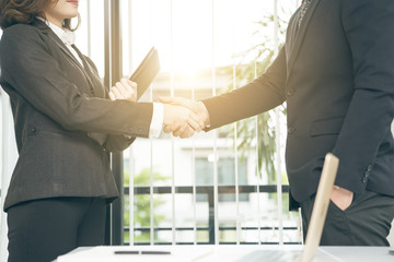 Asian business woman shaking hand with partner after business success or sign contract finish.Woman business concept.