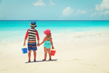 Fototapeta  - little boy and girl play with sand on beach