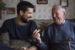 © Jovana Milanko/Stocksy - Grandpa and his grandson sitting at the table talking and laughing
