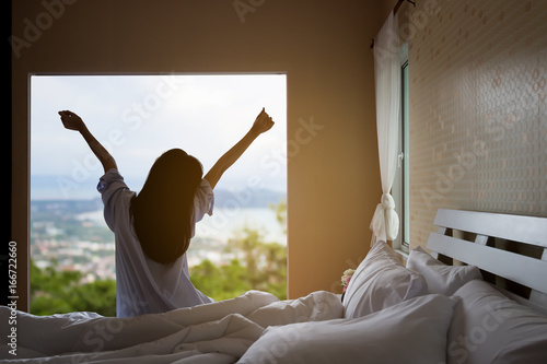 Zdjęcie XXL Szczęśliwa Azjatycka kobieta w ranku na łóżku