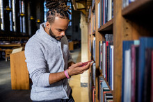 Man Looking At Book In Library