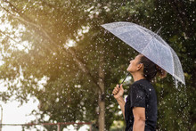 Asian Woman Under An Umbrella In The Rain.