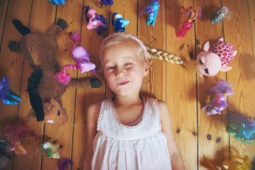 smiling girl with her toys on floor
