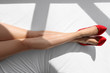 © Africa Studio - Slim female legs in high heels on white sheet