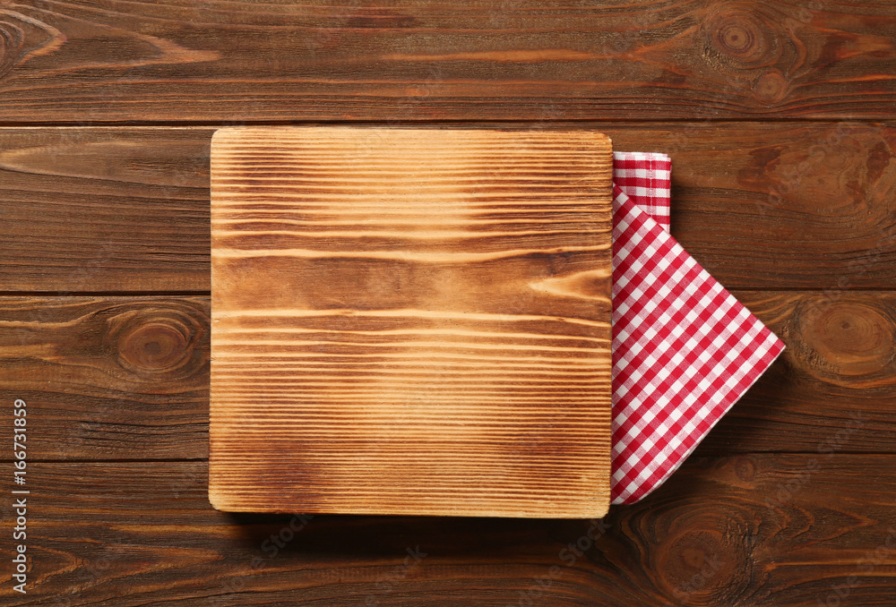 Composition of board and napkin on wooden background