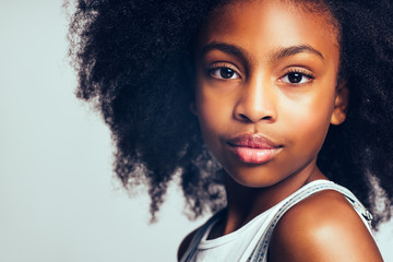 young african girl standing confidently against a gray backgroun