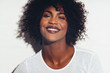 © Flamingo Images - Young African woman smiling happily against a white background