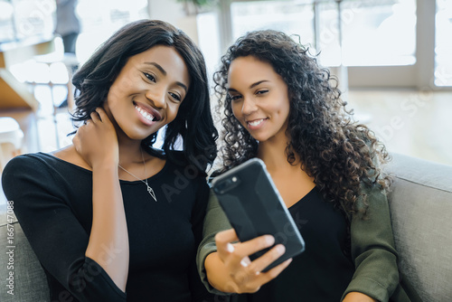 Fotografie, Obraz Women taking selfies with cell phone together