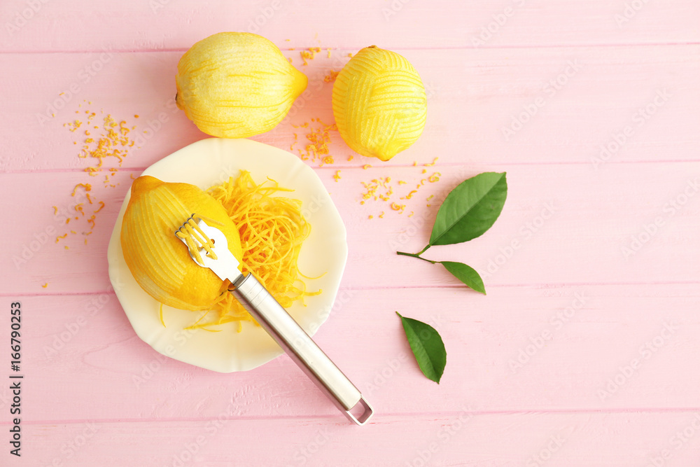 Fresh peeled lemon, special tool and zest on wooden table