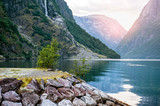 Fototapeta Natura - Golden sunrise in the mountains, Gudvangen Norway with reflection in the water of the fjord.