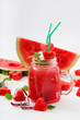 Fresh watermelon smoothies with mint on white wooden background.