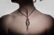 a beautiful handmade pendant with an awesome green stone on the woman's neck