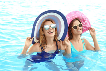 Sticker - Beautiful young women relaxing in blue swimming pool