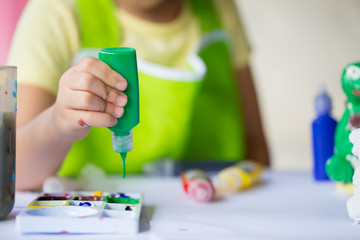 Close up of hand hold color tube for painted on plaster doll