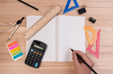 Wall Mural - Math school supplies on wooden table in math class. School concept advertisment with math equipment object on school table. Math back ground concept with boy holding pencil.