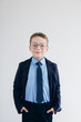 © irina_timokhina - Schoolboy in school uniform and glasses stands on a background o